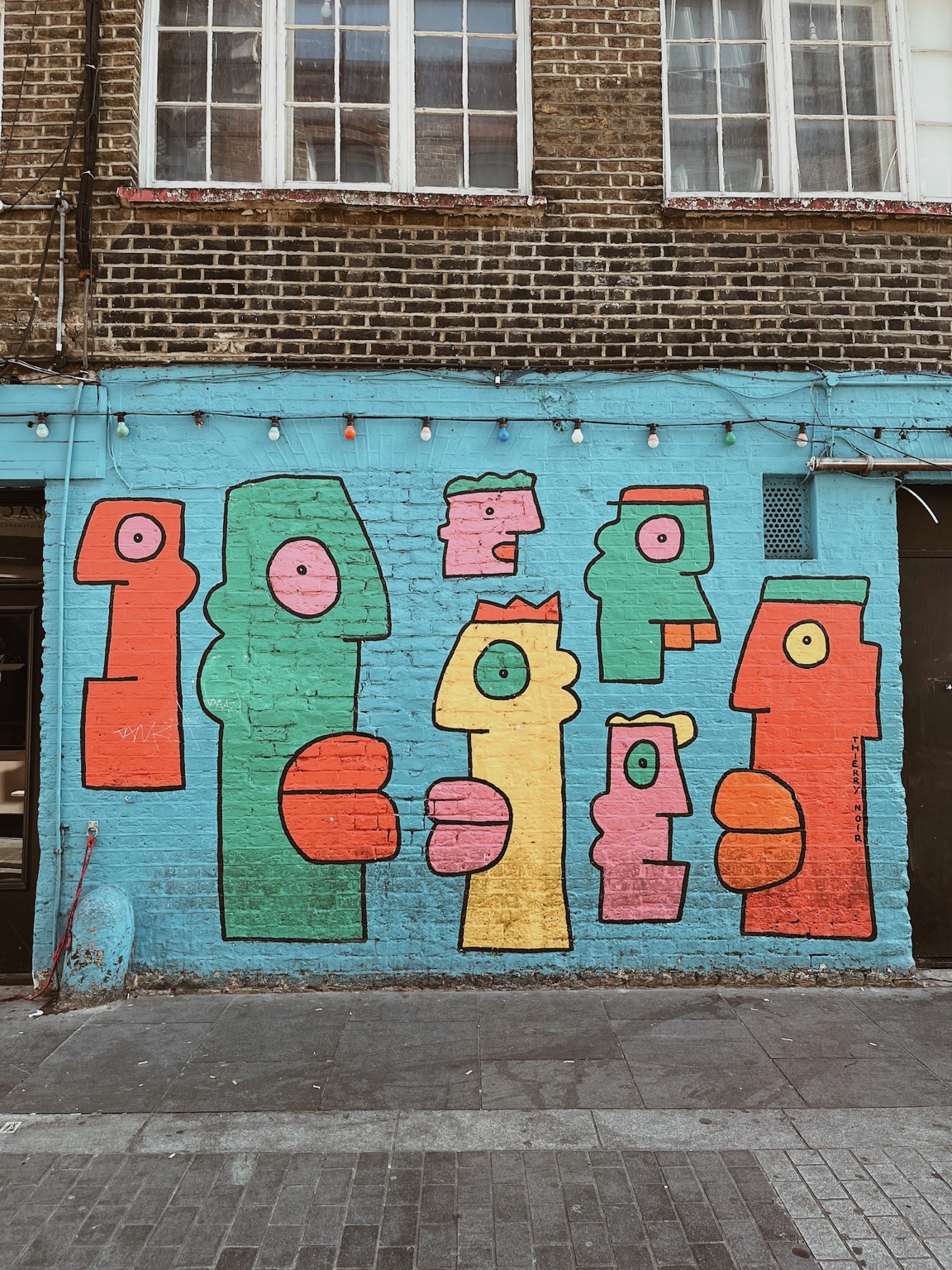 London street art representing profiles with different colors like green, red and yellow.